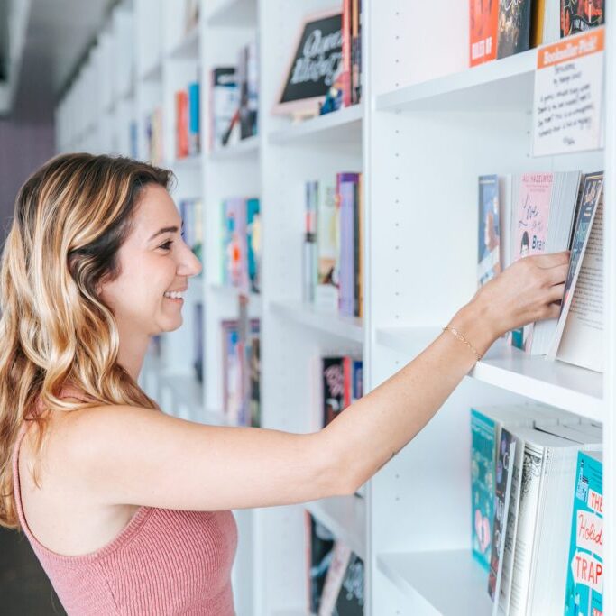 Woman holding a book in a bookstore.